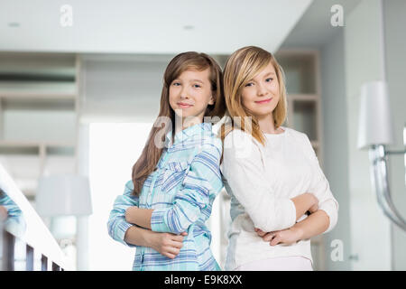 Portrait of cute sisters standing together at home Stock Photo