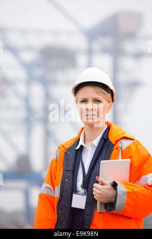 Female engineer holding tablet PC in shipping yard Stock Photo
