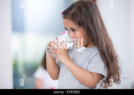 Cute girl drinking glass of water at home Stock Photo