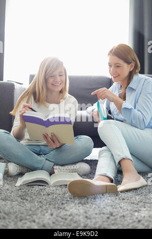 Mother assisting daughter in homework at home Stock Photo