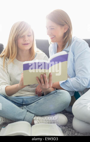 Mother assisting daughter in homework at home Stock Photo