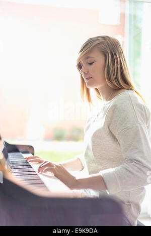 Teenage girl playing piano at home Stock Photo