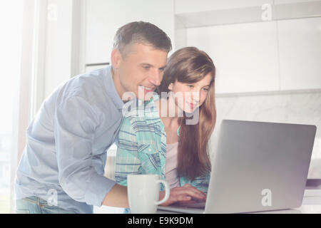 Father and daughter using laptop at home Stock Photo