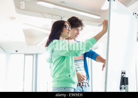 Colleagues preparing presentation on whiteboard in creative office Stock Photo