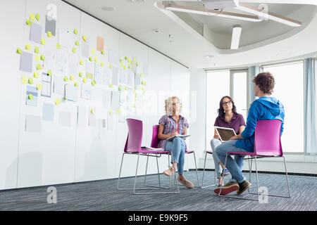 Businesspeople discussing in creative office space Stock Photo
