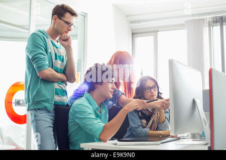Creative business colleagues discussing over computer in office Stock Photo