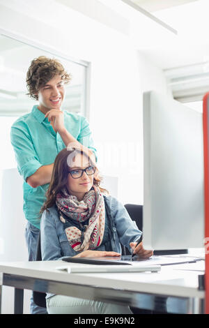 Businesspeople using desktop computer in creative office Stock Photo