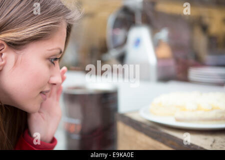 Close-up of woman looking at cake in cafe Stock Photo