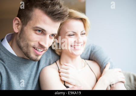 Happy young couple looking away in cafe