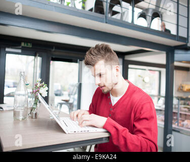 Young man using laptop in cafe Stock Photo