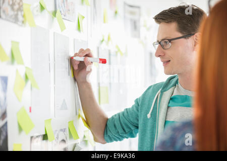 Creative businessman writing notes on paper in office Stock Photo