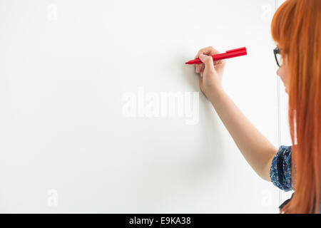 Cropped image of businesswomen writing on whiteboard in creative office Stock Photo