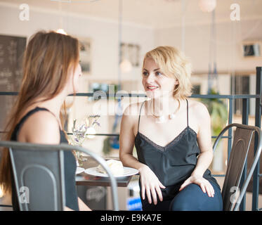 Young female friends spending leisure time at restaurant Stock Photo