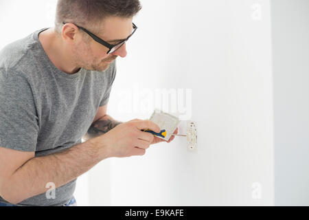 Man working on electrical outlet Stock Photo