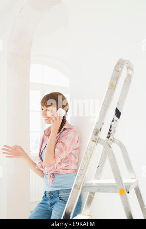 Happy woman using cell phone in new house Stock Photo
