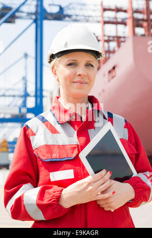 Portrait of confident female engineer holding tablet computer in shipping yard Stock Photo