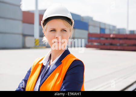 Beautiful female engineer looking away in shipping yard Stock Photo