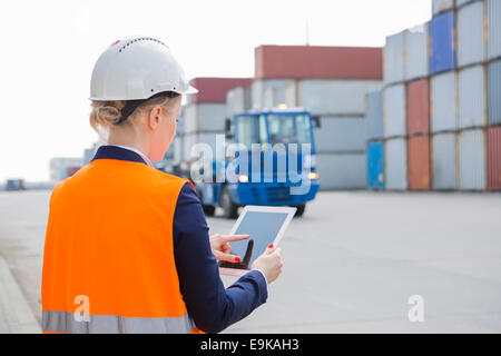 Rear view of female engineer using tablet PC in shipping yard Stock Photo