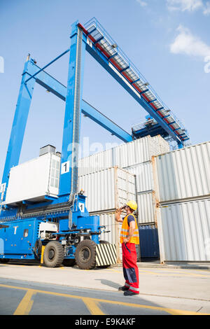 Full-length of worker using walkie-talkie in shipping yard Stock Photo