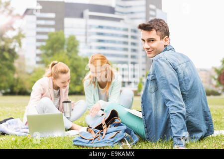 Portrait of young man with female friends studying on university campus Stock Photo