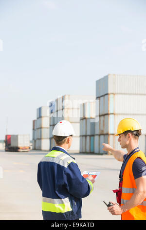 Rear view of male workers discussing in shipping yard Stock Photo