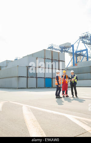 Full-length of workers talking in shipping yard Stock Photo