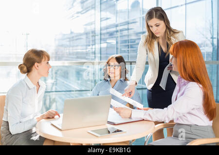 Businesswomen discussing over documents at table in office Stock Photo