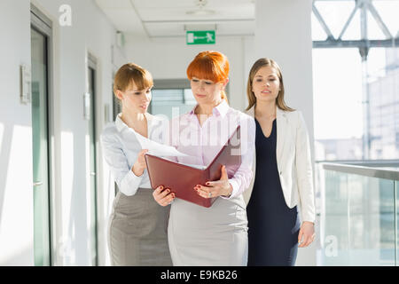 Businesswomen discussing over documents at office hallway Stock Photo