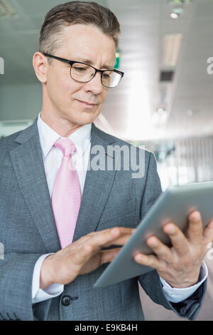 Middle-aged businessman using tablet PC in office Stock Photo