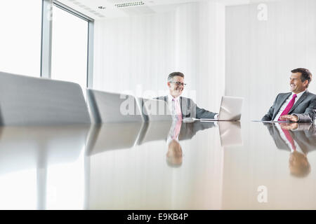 Smiling businessmen talking in conference room Stock Photo
