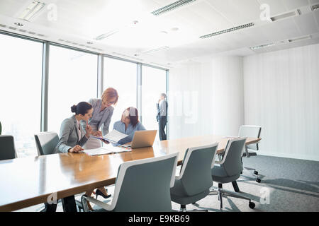 Businesswomen looking at documents in conference meeting Stock Photo