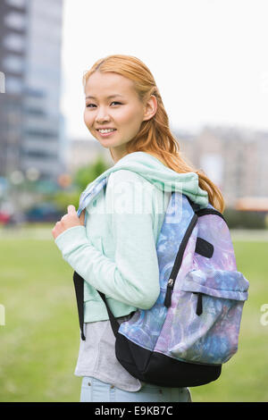 Portrait of happy young woman with backpack at college campus Stock Photo