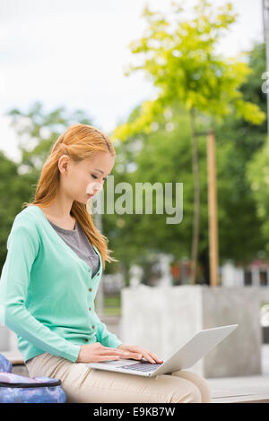 Young woman using laptop at college campus Stock Photo