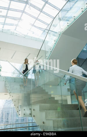 Businesswomen walking on steps in office Stock Photo