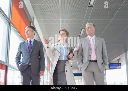 Business people discussing while walking on train platform Stock Photo