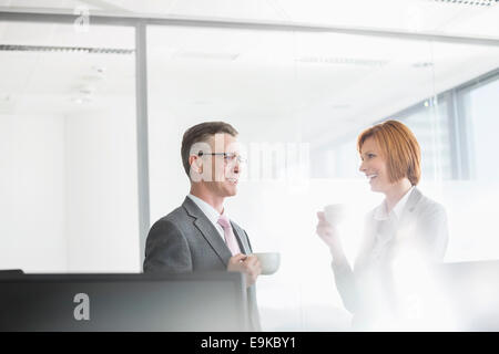 Businessman and businesswoman having coffee in office Stock Photo