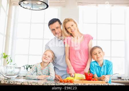 Portrait of happy family preparing food in kitchen Stock Photo