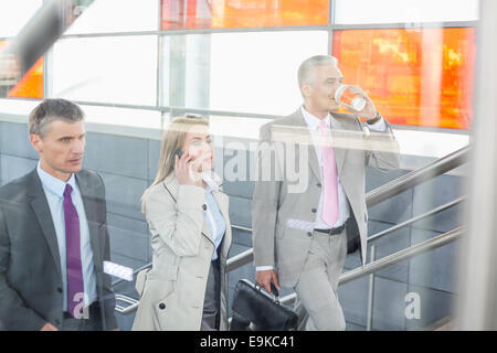Businesspeople walking up stairs in train station Stock Photo