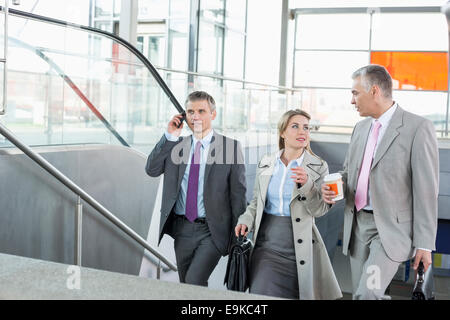 Businesspeople walking up stairs in train station Stock Photo