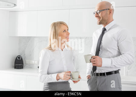 Happy mid adult business couple having coffee in kitchen Stock Photo