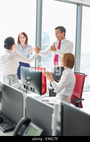 Businesspeople celebrating success in office Stock Photo