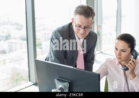 Businessman and businesswoman working together in office Stock Photo