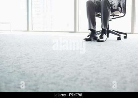 Low section of businessman sitting on office chair Stock Photo