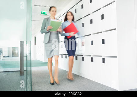 Blurred view of businesswomen walking in office Stock Photo