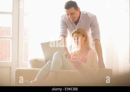 Happy couple using laptop together at home Stock Photo