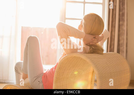 Rear view of woman relaxing on chair at home Stock Photo