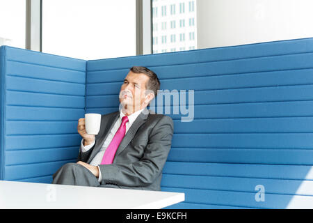 Mature businessman taking coffee break in office Stock Photo