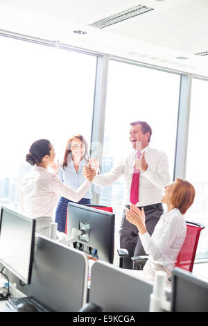 Businesspeople celebrating success in office Stock Photo