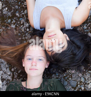 Two teen girl best friends lying on the rocks, top view. Stock Photo