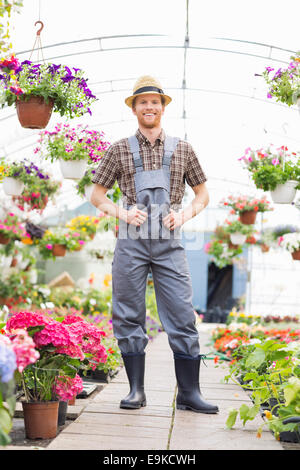 Full length portrait of a male gardener standing with a shovel isolated ...